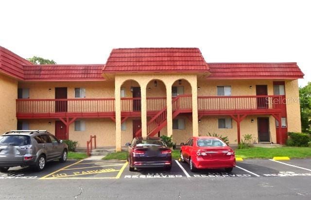 2864 N Powers Dr Unit 156, Orlando, FL 32818 - view of building exterior featuring uncovered parking and stairs