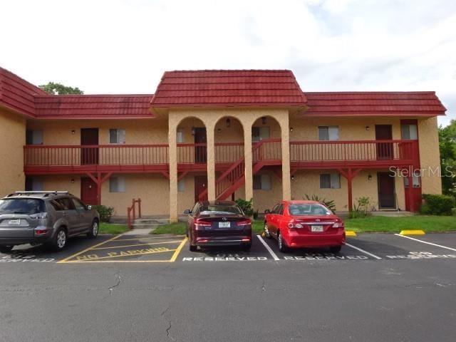 2864 N Powers Dr Unit 156, Orlando, FL 32818 - view of building exterior with uncovered parking and stairs
