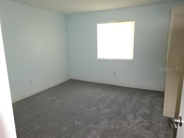 2864 N Powers Dr Unit 156, Orlando, FL 32818 - empty room with dark carpet and baseboards