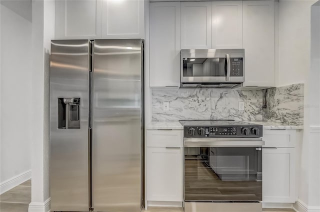 1921 Heathwood Dr, Winter Park, FL 32792 - kitchen featuring appliances with stainless steel finishes, tasteful backsplash, light wood-style floors, and white cabinets