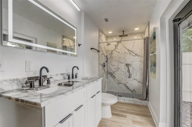 1921 Heathwood Dr, Winter Park, FL 32792 - bathroom featuring wood finished floors, a marble finish shower, vanity, and recessed lighting