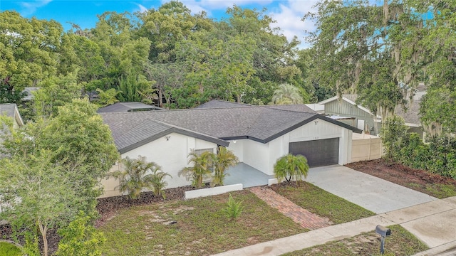 1921 Heathwood Dr, Winter Park, FL 32792 - view of front of home with a shingled roof, an attached garage, and driveway