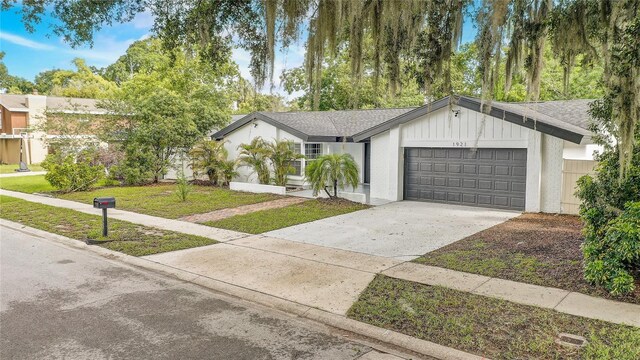 1921 Heathwood Dr, Winter Park, FL 32792 - view of front of home featuring a garage, concrete driveway, and a front lawn