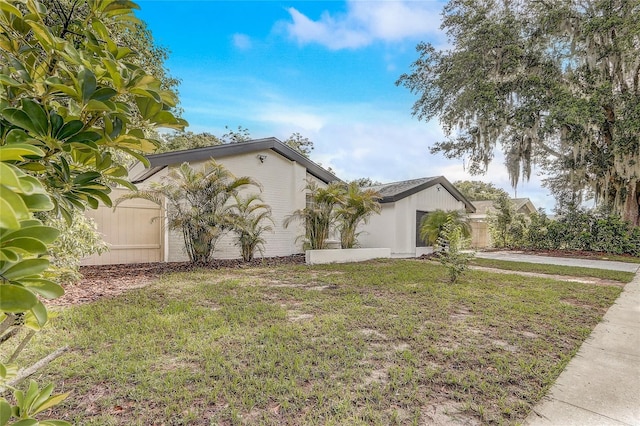 1921 Heathwood Dr, Winter Park, FL 32792 - view of side of property with an attached garage, a lawn, and concrete driveway