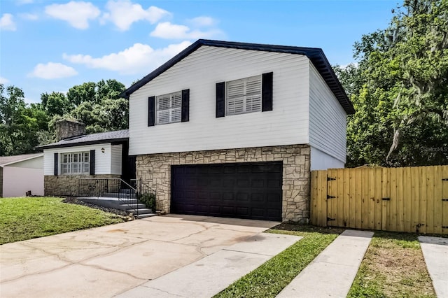 608 Pearl Rd, Winter Springs, FL 32708 - split level home with stone siding, a garage, a gate, and driveway
