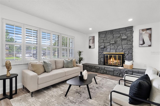 608 Pearl Rd, Winter Springs, FL 32708 - living area featuring wood finished floors, a stone fireplace, recessed lighting, and a textured ceiling