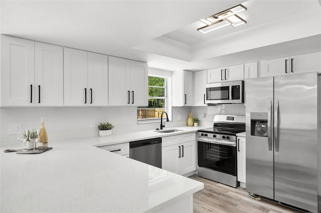 608 Pearl Rd, Winter Springs, FL 32708 - kitchen with appliances with stainless steel finishes, white cabinets, a raised ceiling, light wood-type flooring, and light stone countertops