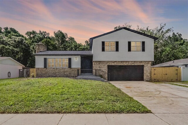 608 Pearl Rd, Winter Springs, FL 32708 - split level home featuring stone siding, a garage, driveway, a gate, and a chimney