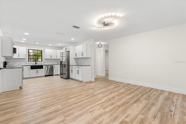 643 Princewood Dr, Deland, FL 32724 - kitchen featuring appliances with stainless steel finishes, light wood finished floors, recessed lighting, white cabinets, and open floor plan