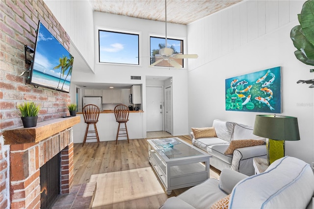 1051 S Highland St Unit 7D, Mount Dora, FL 32757 - living area featuring hardwood / wood-style flooring, ceiling fan, a fireplace, and a towering ceiling