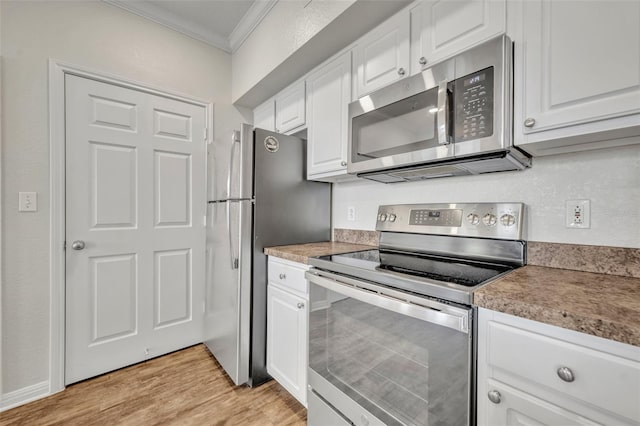 911 N Orange Ave Unit 443, Orlando, FL 32801 - kitchen with appliances with stainless steel finishes, crown molding, white cabinets, and light wood-type flooring