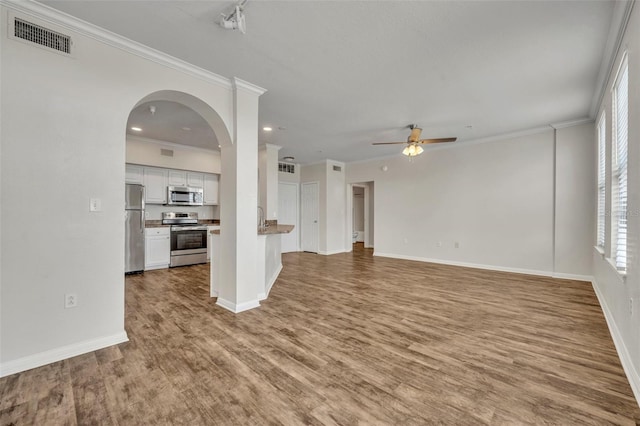 911 N Orange Ave Unit 443, Orlando, FL 32801 - unfurnished living room featuring ceiling fan, wood finished floors, recessed lighting, crown molding, and arched walkways
