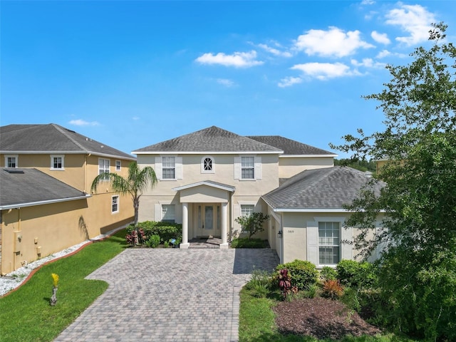 5819 Covington Cove Way, Orlando, FL 32829 - view of front of property featuring stucco siding, decorative driveway, a front lawn, and roof with shingles