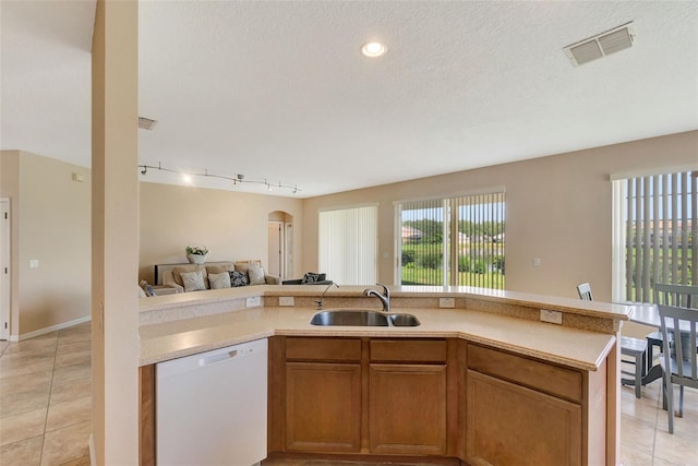 5819 Covington Cove Way, Orlando, FL 32829 - kitchen featuring dishwasher, open floor plan, light countertops, light tile patterned floors, and brown cabinets