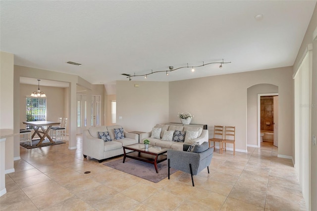 5819 Covington Cove Way, Orlando, FL 32829 - living area featuring arched walkways, a chandelier, and light tile patterned floors