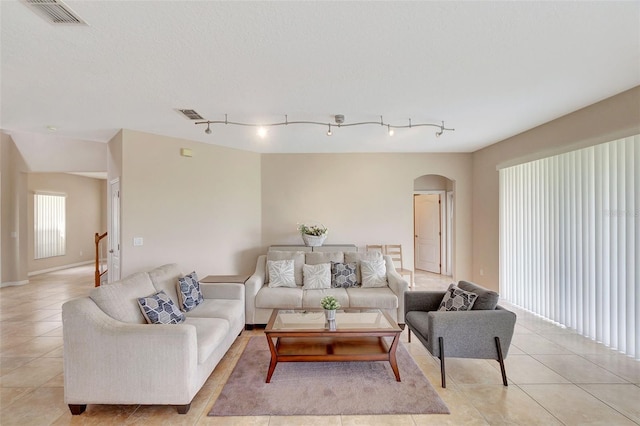 5819 Covington Cove Way, Orlando, FL 32829 - living area with arched walkways, light tile patterned floors, and rail lighting
