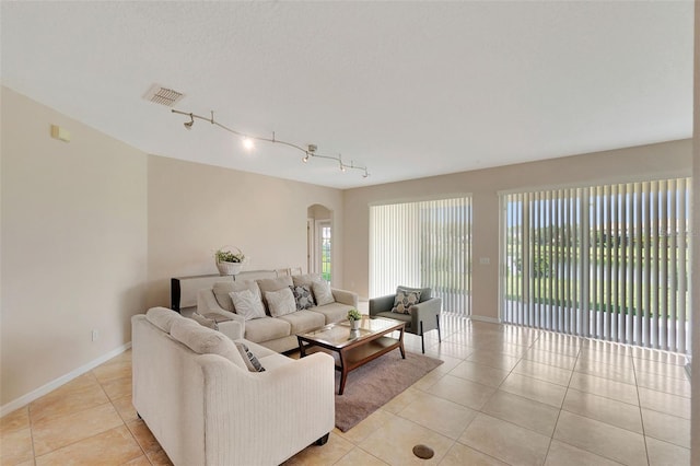 5819 Covington Cove Way, Orlando, FL 32829 - living room featuring arched walkways, light tile patterned floors, and rail lighting
