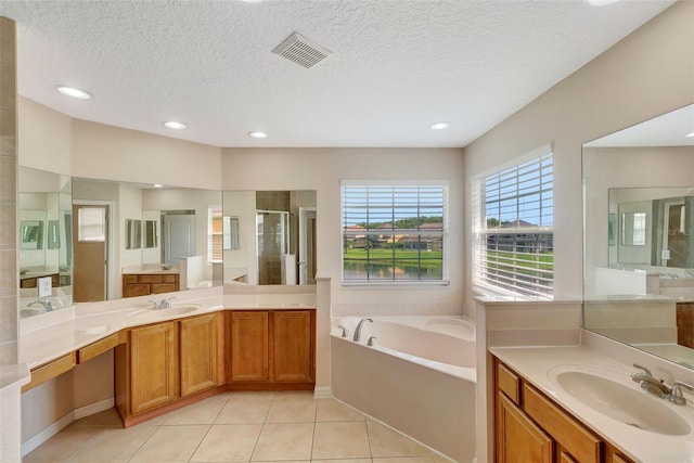 5819 Covington Cove Way, Orlando, FL 32829 - full bath with a stall shower, a garden tub, tile patterned flooring, two vanities, and a textured ceiling