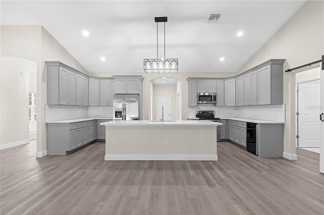 12258 SW 76th Ln, Dunnellon, FL 34432 - kitchen with gray cabinetry, appliances with stainless steel finishes, vaulted ceiling, arched walkways, and tasteful backsplash