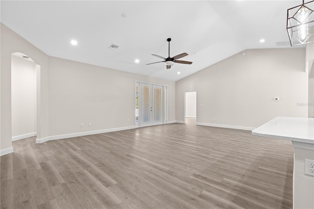 12258 SW 76th Ln, Dunnellon, FL 34432 - unfurnished living room featuring a ceiling fan, vaulted ceiling, arched walkways, light wood finished floors, and recessed lighting
