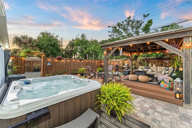 808 Camphor Way, Melbourne, FL 32901 - deck at dusk featuring a hot tub, a gazebo, a fenced backyard, and an outdoor living space