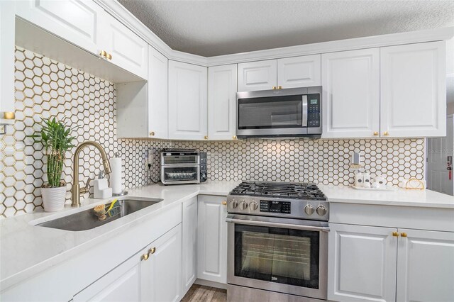 808 Camphor Way, Melbourne, FL 32901 - kitchen with stainless steel appliances, light countertops, white cabinetry, and backsplash