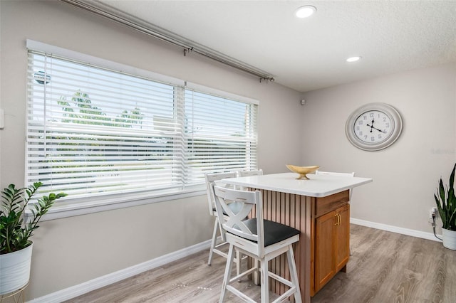 808 Camphor Way, Melbourne, FL 32901 - kitchen featuring light wood finished floors, brown cabinetry, light countertops, recessed lighting, and a kitchen island