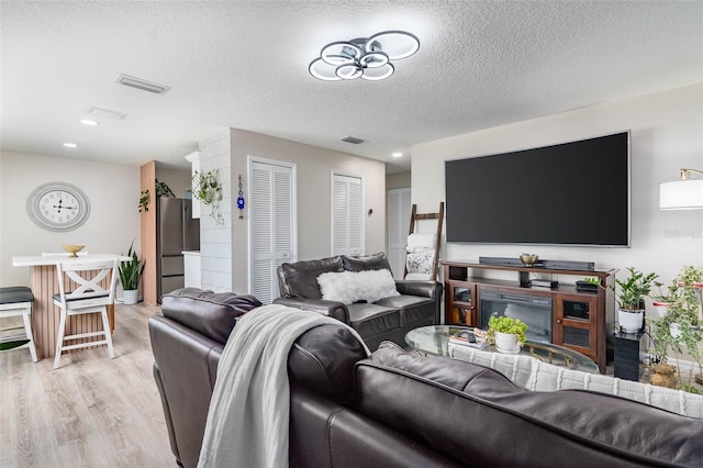 808 Camphor Way, Melbourne, FL 32901 - living room featuring light wood-style flooring, a textured ceiling, and recessed lighting
