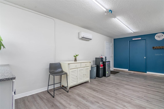 808 Camphor Way, Melbourne, FL 32901 - miscellaneous room with a wall mounted AC, light wood-style flooring, and a textured ceiling