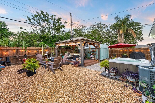 808 Camphor Way, Melbourne, FL 32901 - yard at dusk featuring a hot tub, a gazebo, a fenced backyard, an outdoor hangout area, and a wooden deck