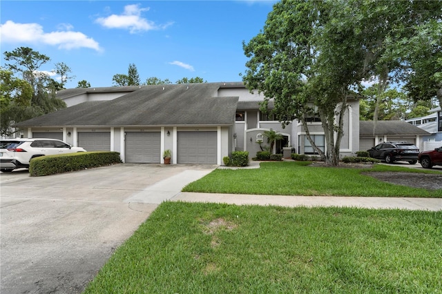 308 N Shadowbay Blvd Unit 214, Longwood, FL 32779 - view of front of property with concrete driveway, an attached garage, a front lawn, and stucco siding