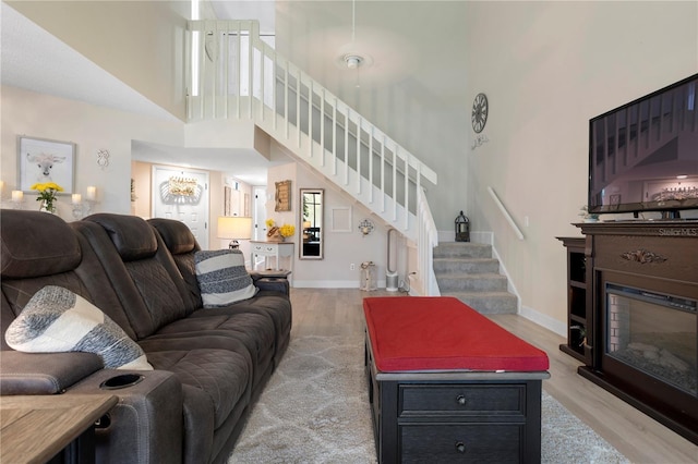 308 N Shadowbay Blvd Unit 214, Longwood, FL 32779 - living room with a high ceiling, light wood finished floors, stairway, and a glass covered fireplace
