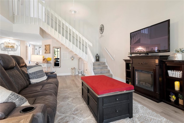 308 N Shadowbay Blvd Unit 214, Longwood, FL 32779 - living room with a high ceiling, stairway, light wood-style flooring, and a glass covered fireplace