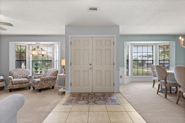 548 Timber Ridge Dr, Longwood, FL 32779 - entryway featuring a chandelier, light carpet, a textured ceiling, plenty of natural light, and light tile patterned floors