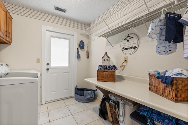 548 Timber Ridge Dr, Longwood, FL 32779 - laundry room with cabinet space, light tile patterned floors, washing machine and clothes dryer, and a textured ceiling