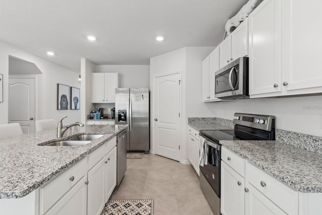 2355 White Lilly Dr, Kissimmee, FL 34747 - kitchen featuring stainless steel appliances, recessed lighting, white cabinetry, light stone countertops, and a kitchen island with sink
