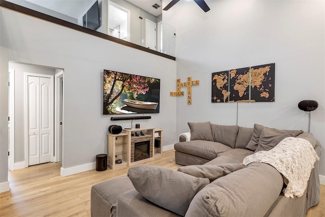 3706 Andover Cay Blvd, Orlando, FL 32825 - living area with ceiling fan, light wood-style flooring, a towering ceiling, and a fireplace