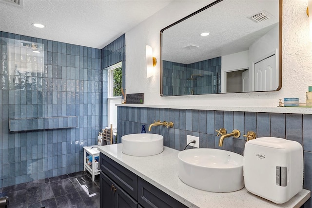 3706 Andover Cay Blvd, Orlando, FL 32825 - full bath featuring a textured ceiling, double vanity, tiled shower, tile walls, and recessed lighting