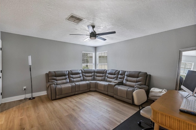 3706 Andover Cay Blvd, Orlando, FL 32825 - living room featuring light wood finished floors, ceiling fan, plenty of natural light, and a textured ceiling