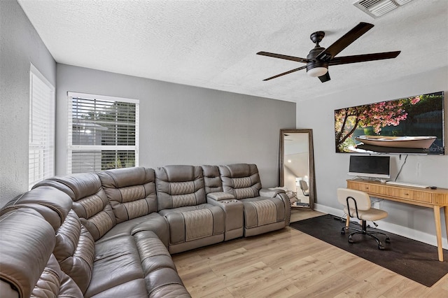 3706 Andover Cay Blvd, Orlando, FL 32825 - living room featuring a textured ceiling, a ceiling fan, and light wood-style flooring