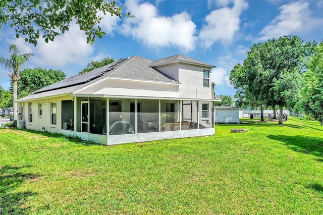 3706 Andover Cay Blvd, Orlando, FL 32825 - rear view of property with a sunroom, solar panels, a lawn, roof with shingles, and stucco siding
