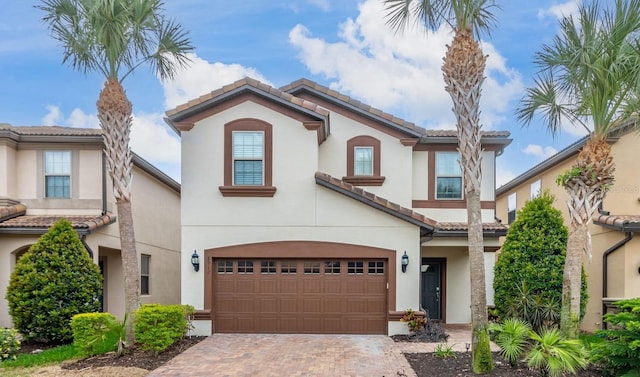 8912 Rhodes St, Kissimmee, FL 34747 - view of front facade featuring an attached garage, a tile roof, stucco siding, and decorative driveway