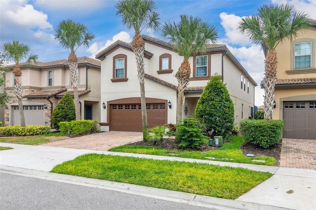 8912 Rhodes St, Kissimmee, FL 34747 - view of front of home with a garage, decorative driveway, stucco siding, and a tile roof