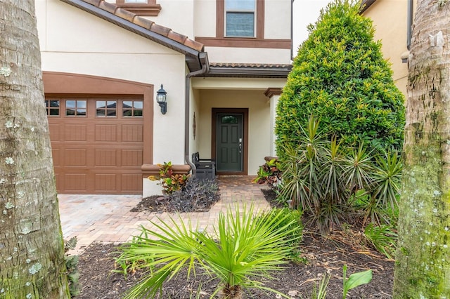 8912 Rhodes St, Kissimmee, FL 34747 - doorway to property with stucco siding, a garage, and driveway