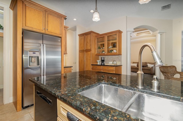 336 Highcroft Ct, Lake Mary, FL 32746 - kitchen with stainless steel fridge with ice dispenser, ornate columns, brown cabinets, arched walkways, and recessed lighting