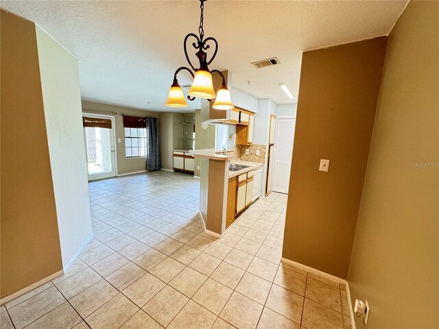 249 Afton Sq Unit 112, Altamonte Springs, FL 32714 - kitchen featuring light countertops, light tile patterned flooring, tasteful backsplash, pendant lighting, and a textured ceiling