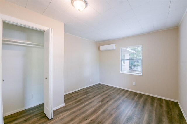 5908 Laconia Rd, Orlando, FL 32808 - unfurnished bedroom with wood finished floors, an AC wall unit, and a closet