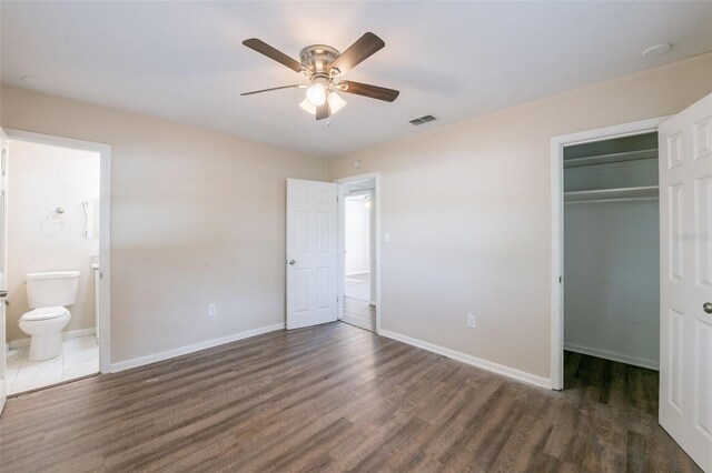 5908 Laconia Rd, Orlando, FL 32808 - unfurnished bedroom featuring wood finished floors, a spacious closet, ensuite bathroom, and a ceiling fan