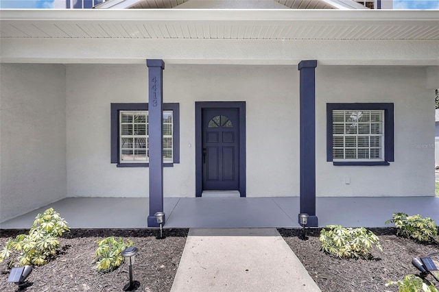 4413 W Wallcraft Ave, Tampa, FL 33611 - doorway to property with a porch and stucco siding