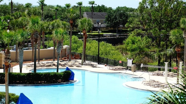 7682 Sir Kaufmann Ct, Kissimmee, FL 34747 - community pool featuring a patio area and view of wooded area